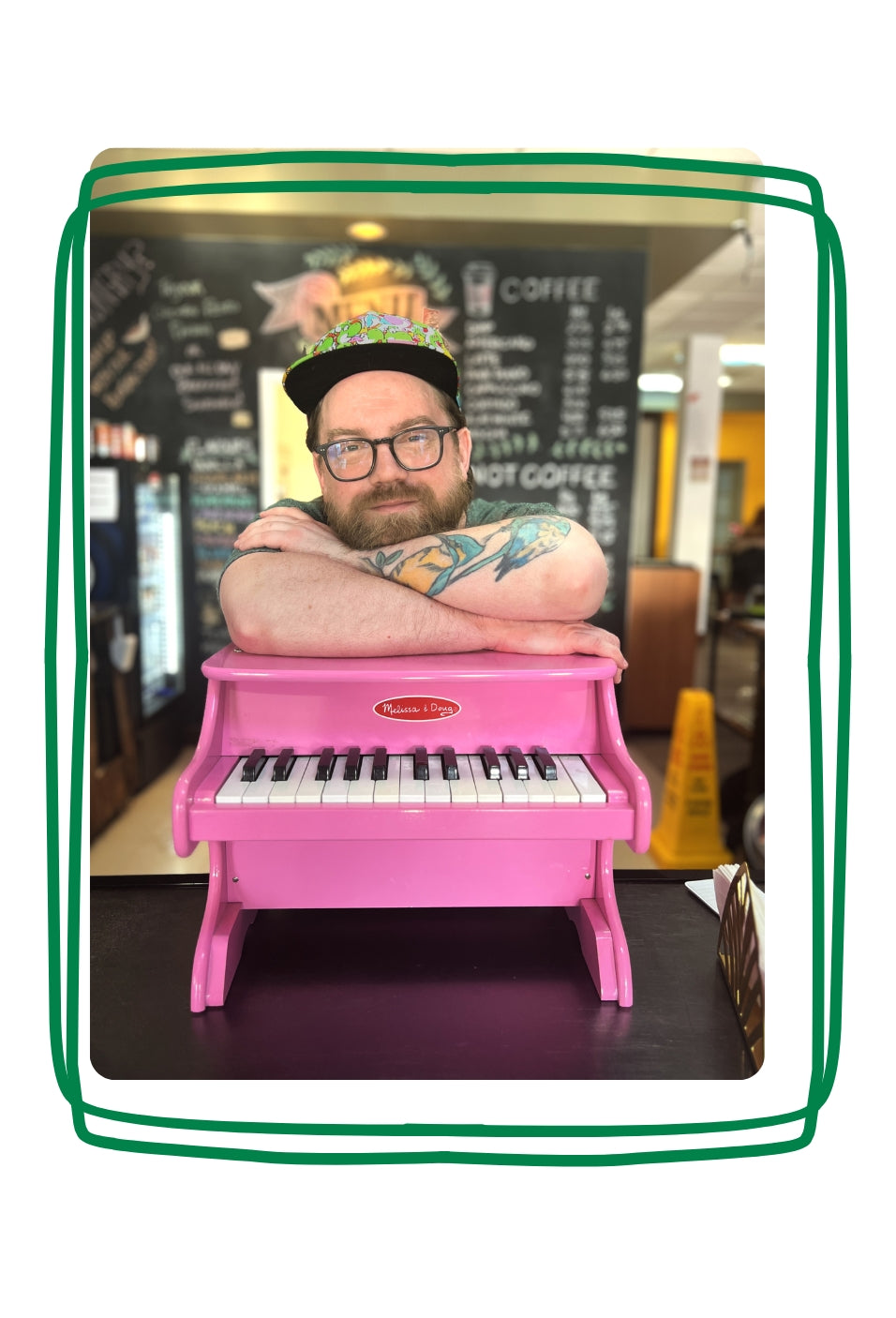 Jay leaning on a small pink piano.